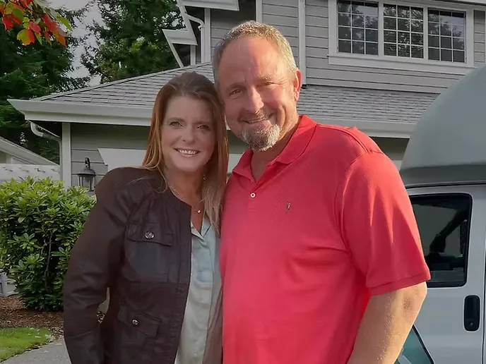 Todd Jensen and his wife centered in front of a Jensen Plumbing service truck